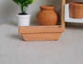 1:12 scale miniature terracotta rectangular planter trough, shown in front of clay pots and a potted plant
