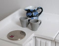 1:12 scale miniature coffee mugs with handles in gray, set of 2, on a white counter beside a coin for scale