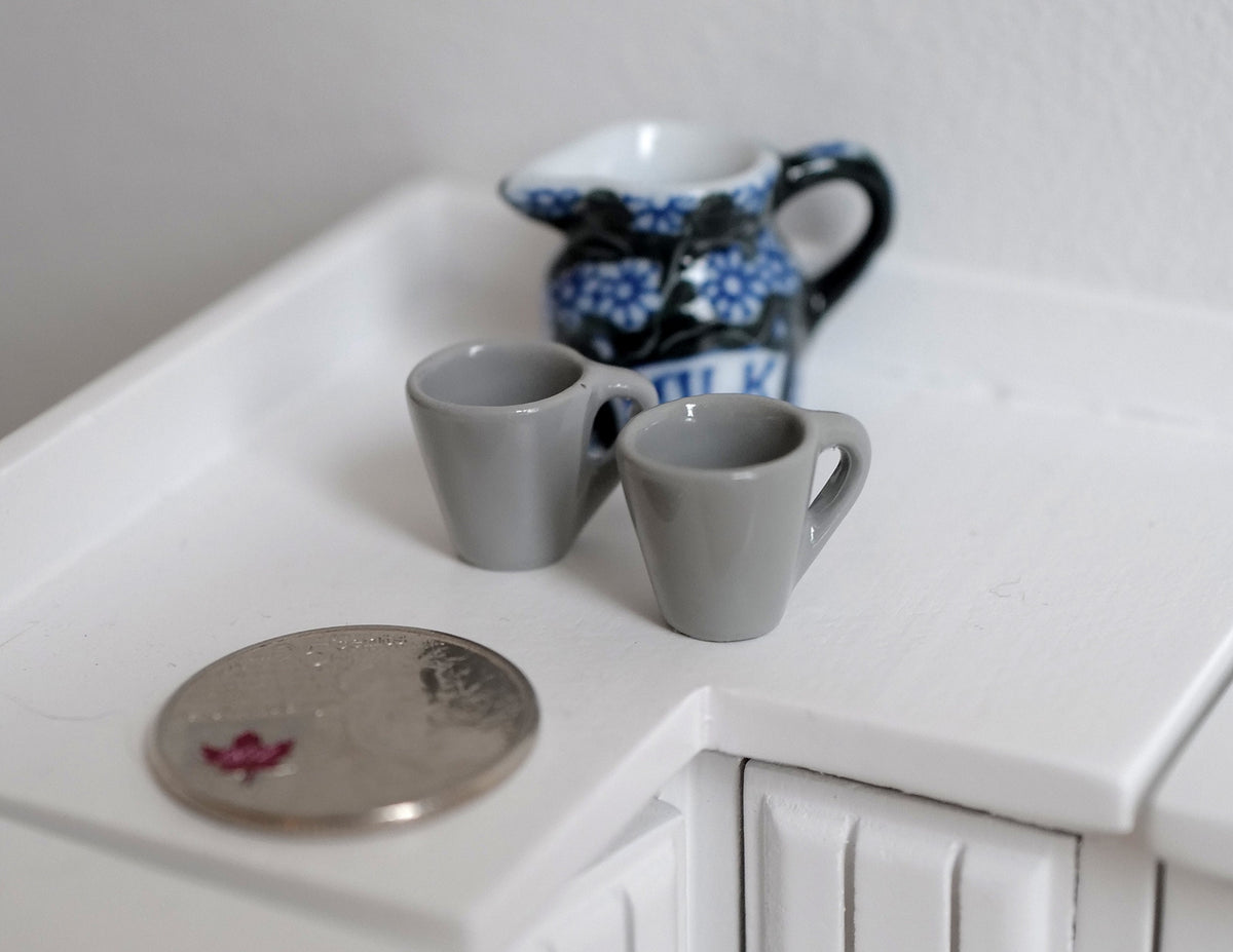 1:12 scale miniature coffee mugs with handles in gray, set of 2, on a white counter beside a coin for scale