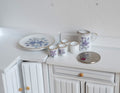 1:12 scale miniature porcelain tea set in blue floral pattern, set of 6 with jug, 4 cups and round tray, on a white counter