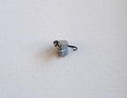 1:12 scale miniature bullet security camera in silver with a thin black antenna, shown on a white surface