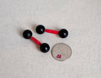 1:6 scale miniature black dumbbells with red bars, set of 2, round ball ends, shown beside a coin for scale