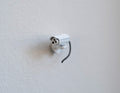 1:12 scale miniature bullet security camera in white with antenna and black cable, shown mounted on a white wall