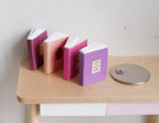 Livres miniatures à l'échelle 1:12 qui s'ouvrent, couvertures pastel avec emblèmes dorés, lot de 4, 2 cm de haut, fourniture pour maison de poupée à faire soi-même