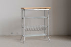 1:12 scale miniature white metal baker's rack with wood top shelf, wire shelves and a bottle rack, on a beige floor