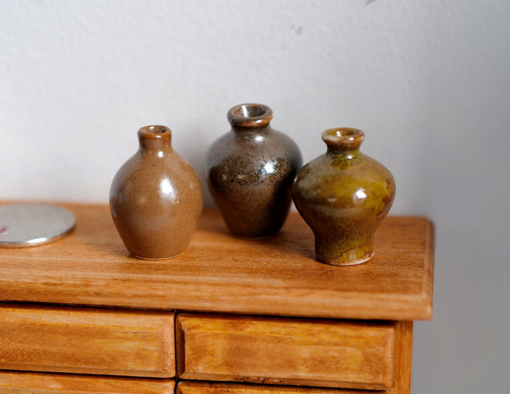 1:12 scale miniature ceramic jug vases in glossy brown, assorted shapes, set of 3, shown on a wood dresser