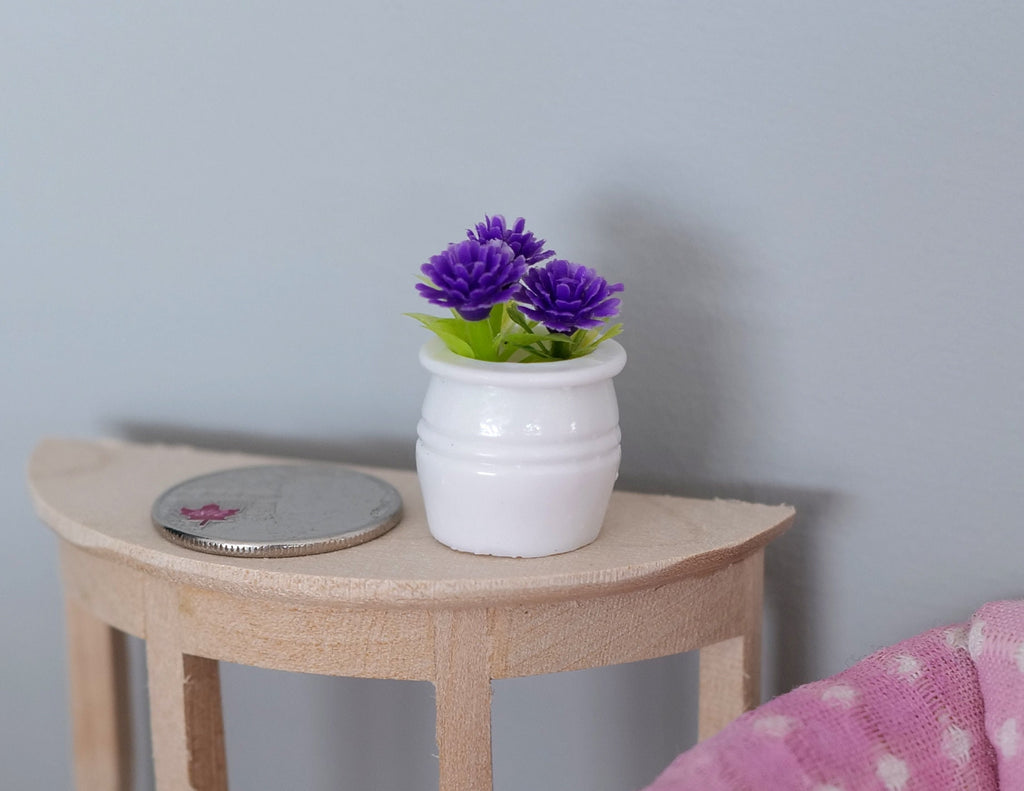 1:12 scale miniature potted plant with purple flowers in a white pot, shown beside a coin on a side table