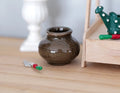 1:12 scale miniature ceramic round vase with wide mouth in dark olive brown glaze, shown on a wood table