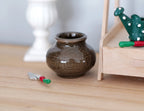 1:12 scale miniature ceramic round vase with wide mouth in dark olive brown glaze, shown on a wood table