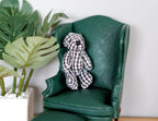 1:12 scale miniature plaid plush bear in black and white with a black nose, sitting on a green armchair