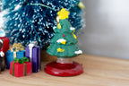 1:12 scale miniature decorated Christmas tree with a yellow top star and red base, shown beside wrapped gift boxes