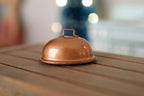 1:12 scale miniature oval serving platter with dome cover in copper, shown on a wood table