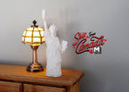 1:12 scale miniature white lady statue figurine with raised torch and crown, shown on a wood dresser beside a lamp