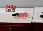 1:12 scale miniature ground meat on a cutting board with a black handled knife, non edible, shown on a kitchen counter