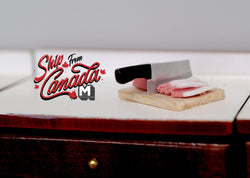 1:12 scale miniature ground meat on a wood cutting board with a cleaver, shown on a dark wood kitchen counter