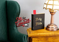 1:12 scale miniature Holy Bible book in black with gold lettering and red ribbon bookmark, on a side table by a lamp