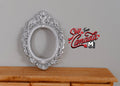 1:12 scale miniature large silver ornate oval photo frame with scrollwork border, shown above a wood dresser