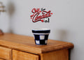 1:12 scale miniature black and white ceramic flower pot with checkered pattern, shown on a wood dresser