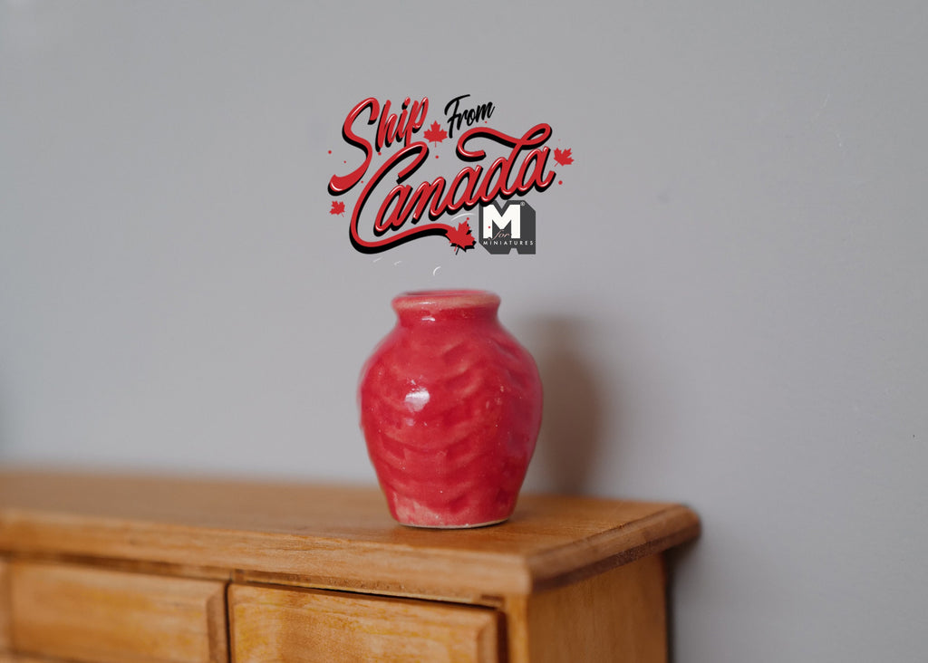 1:12 scale miniature red ceramic plum vase, round with a short neck and glossy glaze, shown on a wood cabinet