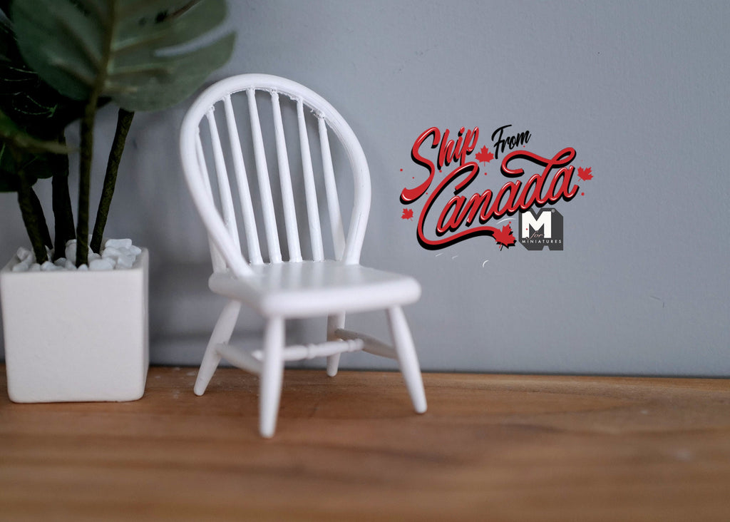 1:12 scale miniature white wood Windsor bow back dining chair with spindles, shown beside a potted plant