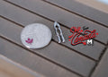 1:12 scale miniature metal nut cracker tool in silver, shown on a gray wood table beside a coin for scale