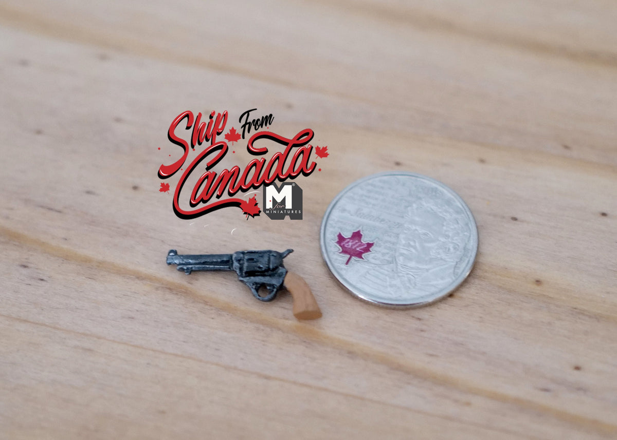 1:12 scale miniature black pistol with brown grip, non working, shown beside a coin for scale