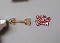 1:12 scale miniature gold towel bar with round end mounts, shown lying on a gray surface