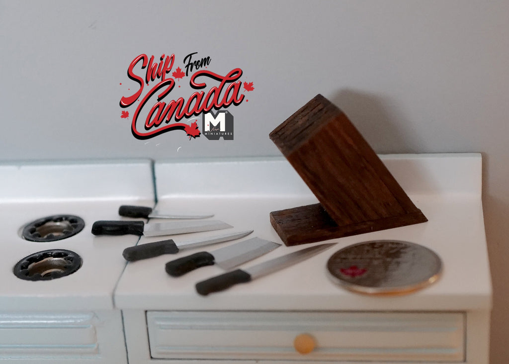 1:12 scale miniature kitchen knife set with wood block, 5 knives with black handles, on a white counter with a coin