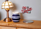1:12 scale miniature ceramic planter pot with blue and white horizontal stripes, on a dresser beside a lamp