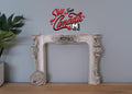 1:12 scale miniature resin Victorian style fireplace mantel in aged gray with ornate relief, shown with a coin for scale