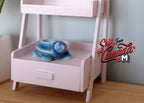 1:12 scale miniature ceramic turtle planter pot in blue with glossy glaze, shown on a pink shelf unit