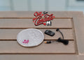 1:12 scale miniature MP3 player with earphones in black and gray, shown on a wood table beside a coin