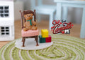 1:12 scale miniature resin teddy bear on pink chair with alphabet blocks, shown on a green round rug