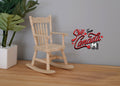 1:12 scale miniature unpainted wood rocking chair with spindle back and arms, on a wood floor beside a potted plant
