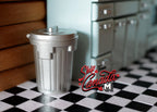 1:12 scale miniature metal garbage can with lid in silver with ribbed sides, on a black and white checkered floor