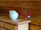 1:12 scale miniature ceramic pomegranate vase in pale aqua, round body with small neck, shown on a wood dresser