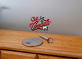 1:12 scale miniature dark red handheld flashlight, classic style, shown on a wood dresser beside a coin for scale