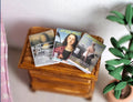 1:12 scale miniature magazines with printed color covers, set of 3, can open, shown on a wood side table by a plant