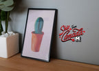 1:12 scale miniature framed cactus art print with a black frame, green cactus in a terracotta pot, leaning on a wall