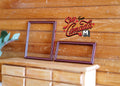 1:12 scale miniature metal picture frames in dark red, set of 2, empty frames shown leaning on a wood dresser
