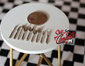 1:12 scale miniature metal flatware set in silver, knives, forks and spoons, set of 9, on a white table with a coin