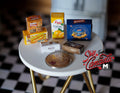 1:12 scale miniature grocery boxes with assorted cereal and food prints, set of 6, on a white table beside a coin