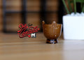 1:12 scale miniature brown glazed ceramic footed urn planter with scalloped rim, shown on a wood table