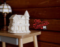 1:12 scale miniature unpainted resin little house decoration in white with gabled roof, shown on a side table