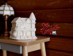 1:12 scale miniature unpainted resin little house decoration in white with gabled roof, shown on a side table