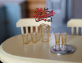 1:12 scale miniature pitcher and 4 glasses in clear amber, set of 5, with cut pattern, on a cream table beside a coin