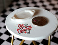 1:12 scale miniature ceramic oval tray in white with side handles, on a round table beside a coin for scale