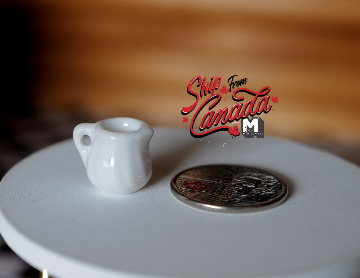 1:12 scale miniature small porcelain jug in white with a handle, shown on a round table beside a coin for scale
