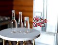 1:12 scale miniature clear glass bottles in three shapes, set of 3, shown on a round white table