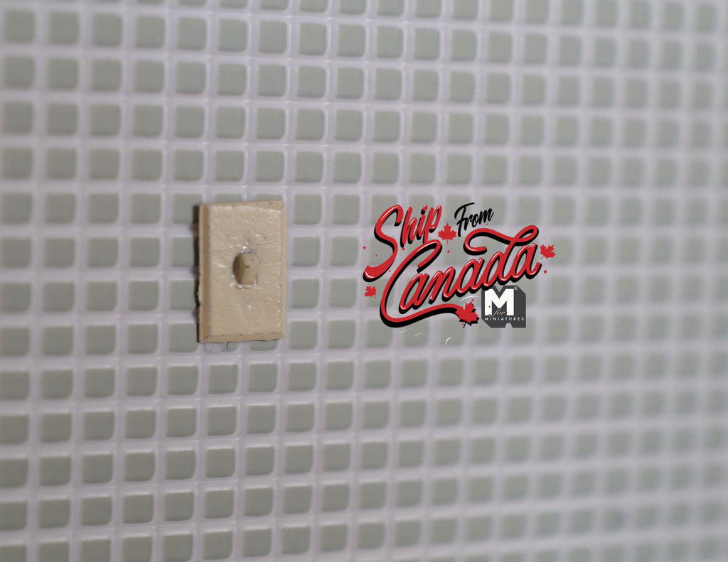 1:12 scale miniature modern rocker wall switch in beige, shown mounted on a white square tile wall